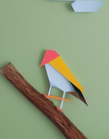 A paper cut of a bird sitting on a branch