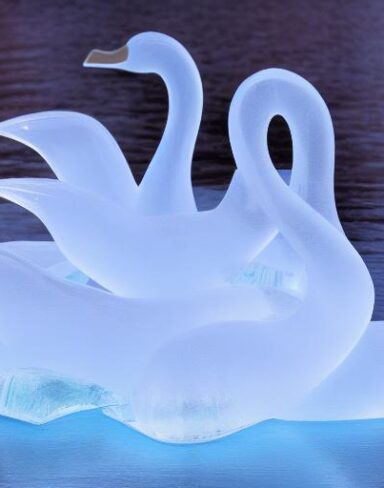 An tranquil ice sculpture of two glowing ice-made swans on a wave
