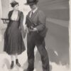 A man standing next to a woman holding a gun A man standing next to a woman holding a gun