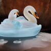 An tranquil ice sculpture of two flowing ice-made swans on a wave An tranquil ice sculpture of two flowing ice-made swans on a wave